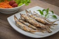 Grilled fish capelin or shishamo on plate and salad in bowl