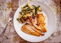 Grilled fish fillet and scrambled eggs and vegetables on plate, top view Royalty Free Stock Photo