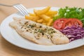 Grilled fish fillet steak with herb and french fries on plate Royalty Free Stock Photo