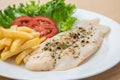 Grilled fish fillet steak with herb and french fries on plate Royalty Free Stock Photo