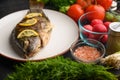 Grilled fish with fresh vegetables, on a wooden black background. I also eat healthy food. Seafood, Eastern or European cuisine Royalty Free Stock Photo