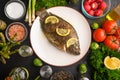 Grilled fish with fresh vegetables, on a wooden black background. I also eat healthy food. Seafood, Eastern or European cuisine Royalty Free Stock Photo