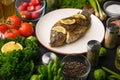 Grilled fish with fresh vegetables, on a wooden black background. I also eat healthy food. Seafood, Eastern or European cuisine Royalty Free Stock Photo