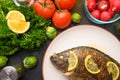 Grilled fish with fresh vegetables, on a wooden black background. I also eat healthy food. Seafood, Eastern or European cuisine Royalty Free Stock Photo