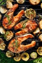 Grilled fish, grilled salmon steak with the addition of rosemary, aromatic spices and vegetables on the grill plate outdoors Royalty Free Stock Photo