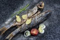 Grilled fish with spices, vegetables and herbs on slate background ready for eating. Royalty Free Stock Photo