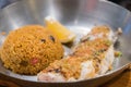 Grilled fish steak served with fried rice and lemon in a deep pan placed Royalty Free Stock Photo