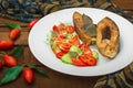 Grilled fish steak with vegetables on plate: tomatoes, microgran, cucumber, tasty and healthy dinner. Wooden rustic background. To Royalty Free Stock Photo