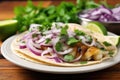 grilled fish taco garnished with cilantro and onions