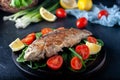 Grilled fish with tomatoes, spinach on a wooden board. Delicious and light dinner Royalty Free Stock Photo