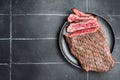 Grilled Flap or Flank Steak, sliced on a plate. Black background. Top view. Copy space Royalty Free Stock Photo