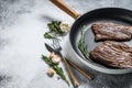 Grilled flat iron and flank steaks in a pan. Marble beef meat. Gray background. Top view. Copy space
