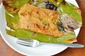 grilled flower crab with curry paste in banana leaf and silver fork on plate