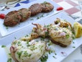 Grilled fresh squid with olive oil and lemon, and zucchini fritters in background, Chania on Crete Island Royalty Free Stock Photo