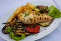 Grilled fresh squid on white plate with chips and vegetables Royalty Free Stock Photo