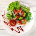 Grilled fried meat on a plate with salad and herbs, shish kebab in tomato sauce Royalty Free Stock Photo