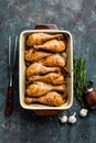 Grilled fried roast chicken legs, drumsticks on dark background, meat with ingredients for cooking Royalty Free Stock Photo