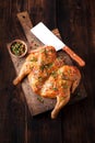 Grilled fried roast chicken tobacco on cutting board on dark wooden background