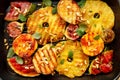 Grilled fruits; pineapples, peaches, figs, pears and watermelon with pine nuts, fresh herbs and honey on the grill plate, top view