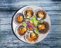 Grilled Galician Scallops with salad on blue wooden table. Iberic Variegated Scallops ZamburiÃÂ±as Royalty Free Stock Photo