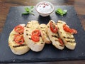 grilled garlic bread with tomatos on slate plate with tzaziki dip Royalty Free Stock Photo
