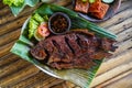 Grilled gurami or grilled gurame with red barbecue sauce, vegetables and chili sauce served on banana leaves Royalty Free Stock Photo