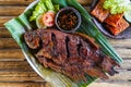 Grilled gurami or grilled gurame with red barbecue sauce, vegetables and chili sauce served on banana leaves