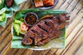 Grilled gurami or grilled gurame with red barbecue sauce, vegetables and chili sauce served on banana leaves