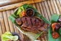 Grilled gurami or grilled gurame with red barbecue sauce, vegetables and chili sauce served on banana leaves