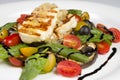 Grilled Halloumi Cheese poured with garlic olive oil salad witch grilled eggplant, cherry tomatoes, black olives and spinach Royalty Free Stock Photo