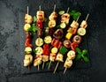 Grilled Halloumi cheese skewers with vegetables on rustic stone board