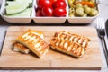 Grilled haloumi cheese on a wooden board with olives, cherry, cucumbers and pepperoni Royalty Free Stock Photo