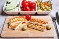 Grilled haloumi cheese on a wooden board with olives, cherry, cucumbers and pepperoni Royalty Free Stock Photo