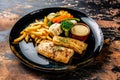 Grilled Hamour fish with french fries dip and salad served in dish isolated on background top view of seafood grill Royalty Free Stock Photo