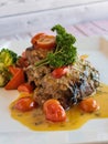 GRILLED HAMOUR Fish with gravy, broccoli and tomato served in dish isolated on table closeup top view of grilled seafood