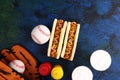 Grilled hot dogs with mustard and ketchup on the table with draft beer. Baseball party food with balls for the playoffs