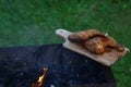 Grilled hot grilled chicken thighs on a grill on a wooden board with smoke around. outdoors. Free space for text Royalty Free Stock Photo