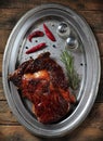 Grilled juicy beef steak with rosemary, salt, pepper and chili pepper on an iron plate on the wooden table Royalty Free Stock Photo