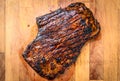 Grilled juicy marinated beef flank steak on wooden board