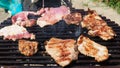 Grilled juicy meat pork steaks in burning coals on a barbecue grill, white smoke. Crispy crust. Tasty steak with Royalty Free Stock Photo