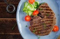 Grilled juicy steak medium rare beef with spices and fresh salad. Royalty Free Stock Photo