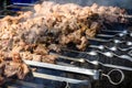 Grilled kebab cooking on metal skewer. Roasted meat cooked at barbecue. BBQ fresh pork meat chop slices. Eastern dish, shish kebab Royalty Free Stock Photo