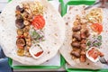 Grilled kebab with pita bread and vegetables on tray in summer fast food street cafe, top view