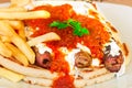 Grilled kebab under yogurt sauce and tomato