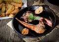 Grilled lamb chops with garlic and herbs in a pan on a dark wooden background Royalty Free Stock Photo