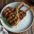 Grilled lamb chops plated with fresh rosemary on a rustic wooden table Royalty Free Stock Photo