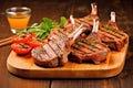 grilled lamb chops stacked on a wooden chopping board Royalty Free Stock Photo