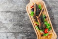 Grilled lamb ribs in herbs and greens, fresh salad, grilled vegetables and berries on cutting board on wooden background. Royalty Free Stock Photo