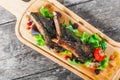 Grilled lamb ribs in herbs and greens, fresh salad, grilled vegetables and berries on cutting board on wooden background Royalty Free Stock Photo