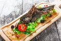 Grilled lamb ribs in herbs and greens, fresh salad, grilled vegetables and berries on cutting board on wooden background Royalty Free Stock Photo